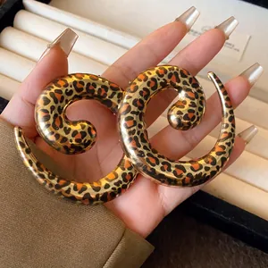 Detail view showing the bold leopard print on an exaggerated geometric U-shaped necklace.