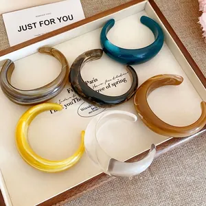 Bracciali aperti in resina marmorizzata in vari colori per un look alla moda e audace
