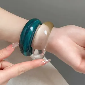 Coppia di grossi bracciali rigidi in resina marmorizzata verde e trasparente
