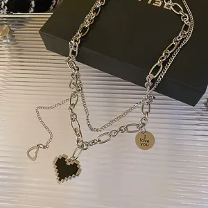 Nahaufnahme einer silberfarbenen Schichtkette mit Pixelherz und 'I love you'-Anhänger