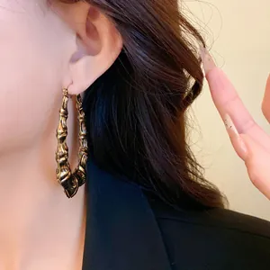 Macro view of vintage gold U-shaped hoop earring featuring textured bamboo design