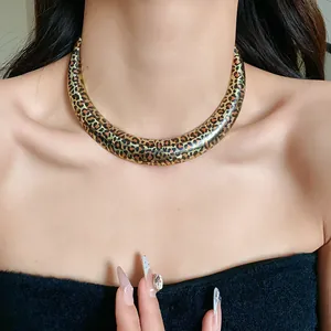 Exaggerated geometric U-shape gold choker with bold leopard print pattern worn by model