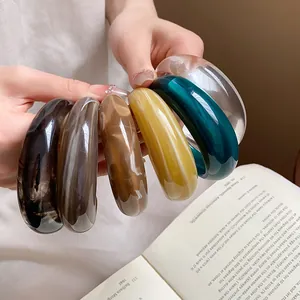 Primo piano di bracciali colorati in resina acrilica marmorizzata lucidi