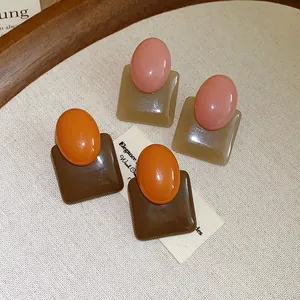 Detail view of retro resin stud earrings featuring contrast colors and geometric shapes