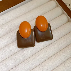 Elegant retro resin stud earrings featuring an orange oval and brown square geometric design