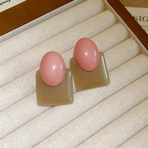 Macro view of French retro color-block resin stud earrings in a beige jewelry box