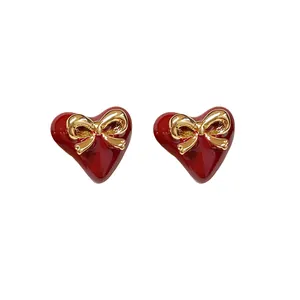 Elegant red heart-shaped stud earrings with decorative gold-plated bowknot design for women