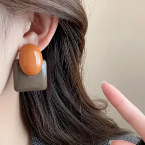 Detail of French vintage resin stud earrings with orange and grey contrast design