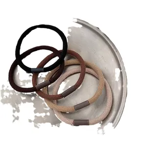 Set of five minimalist high-elastic hair ties in neutral earth tones on a metal tray