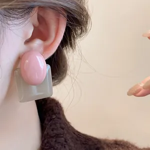 Close-up of French vintage resin earrings featuring pink and grey color-blocking
