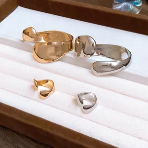 Detailed view of minimalist irregular smooth gold and silver open rings and bangles jewelry