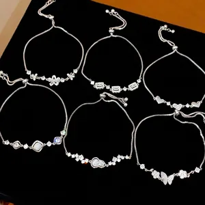 Elegant silver-toned adjustable bracelets with butterfly and zircon accents on black velvet