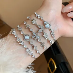 Detailed view of elegant silver bracelets with CZ butterflies and floral motifs on wrist