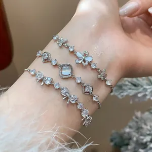 Set of three elegant zircon bracelets with butterfly and flower motifs on a wrist