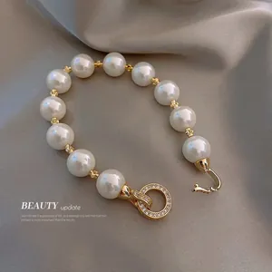 Détail d'un bracelet de perles rétro français avec un fermoir en strass doré scintillant