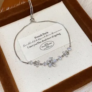 Detailed view of a silver-toned bracelet featuring delicate zircon flowers and butterflies.