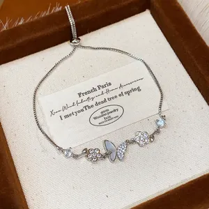 Close-up of elegant silver butterfly and flower bracelet with zircon stones in a gift box.