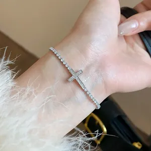 Detailed view of a sparkling silver zircon cross tennis bracelet worn on a female wrist