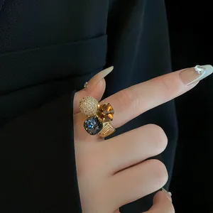 Close-up of a luxurious gold-plated geometric ring featuring multi-colored sparkling zircons.