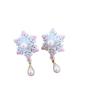 Pendientes de gota de copo de nieve con detalles rosas y perlas colgantes en fondo blanco