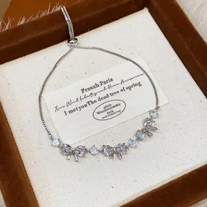 Close-up of elegant silver-colored bracelet with zircon butterfly charms in a gift box