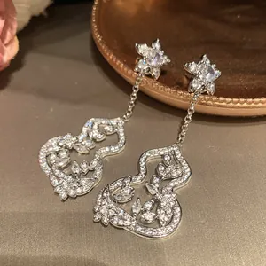 Detailed macro shot of New Chinese style silver gourd tassel earrings with zircon stones
