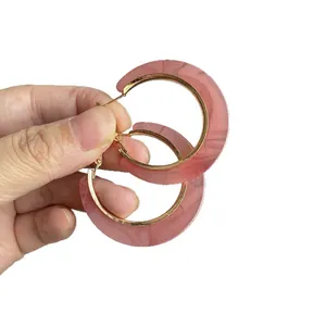 Vintage acetate C-shaped hoop earrings with pink marble pattern and gold metal finish.