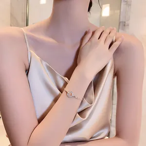 Detalle de pulsera dorada elegante con anillo de pavé en la muñeca de una modelo.