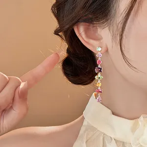 Detail showing luxury multi-colored cubic zirconia long tassel earring on female ear