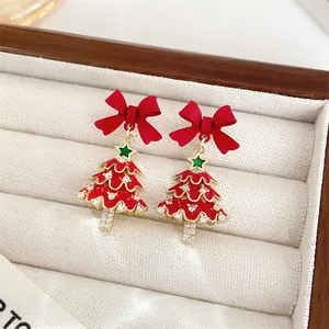 Macro view of festive red bow Christmas tree earrings with sparkling crystal accents