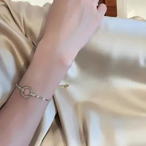 Primer plano de pulsera ajustable dorada con círculo pavé brillante en la muñeca
