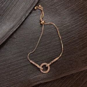 Detalle de pulsera ajustable de oro rosa con círculo de cristales en micro-pavé.