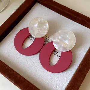 Vintage geometric acrylic stud earrings with matte red oval and pearlescent white disc