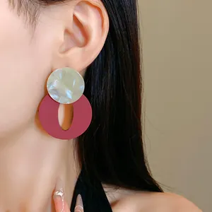 Close-up view of vintage acrylic round and oval earrings in burgundy and white