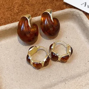Parure de boucles d'oreilles vintage en résine ambre avec créoles dorées de style rétro.