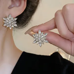 Detailed view of silver needle flower stud earrings with brilliant crystal accents