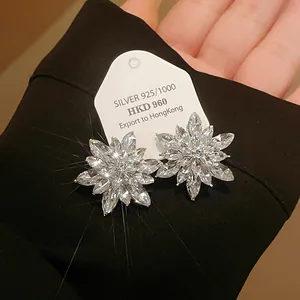 Close-up of sparkling flower-shaped stud earrings with clear marquise-cut crystals