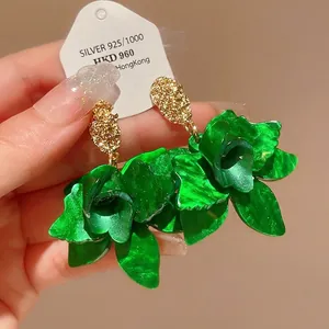 Elegant green flower drop earrings with textured gold studs and silver needle backings.