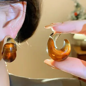 Vue macro détaillée de boucles d'oreilles en résine ambre vintage avec accents dorés