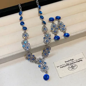 Close-up of elegant vintage French style blue crystal floral necklace and earring set.