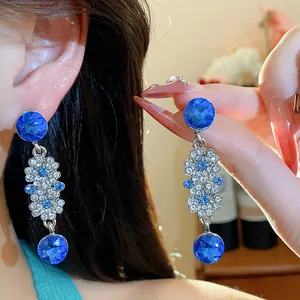 Detail view of blue crystal floral drop earrings with sparkling rhinestones in retro style