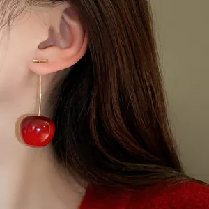 Detailed macro shot of a realistic red cherry drop earring worn on a model ear