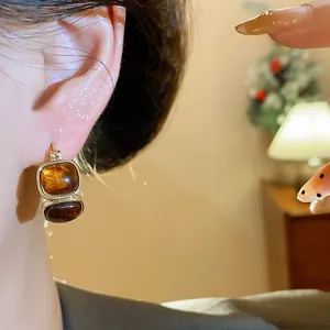 Gros plan de boucles d'oreilles vintage en résine ambrée avec une finition dorée