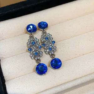 Detailed close-up view of French vintage floral drop earrings with sparkling blue rhinestones