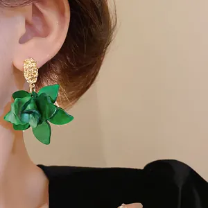 Detailed close-up view of a stylish green flower petal drop earring worn on the ear