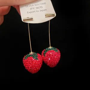 Close-up of sparkling red crystal strawberry earrings with 925 silver tag detail