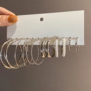Elegantes silbernes Ohrring-Set mit Perlen und strukturierten Creolen.