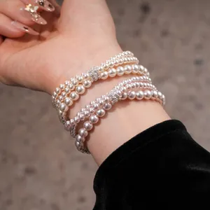 Macro view of multi-strand pearl bracelet with sparkling zircon accents on wrist
