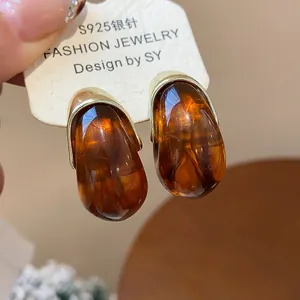 Gros plan montrant les détails des boucles d'oreilles vintage en résine ambrée