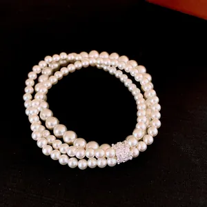 Detailed view of elegant multi-layered white pearl bracelet with shiny zirconia clasp